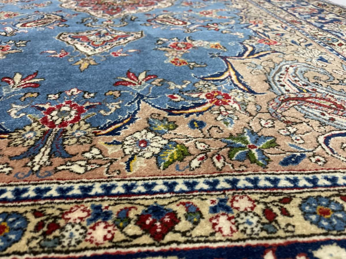 Persian rug in dimensions 220 centimeters length by 140 centimeters width with mainly blue colors — Texture close-up