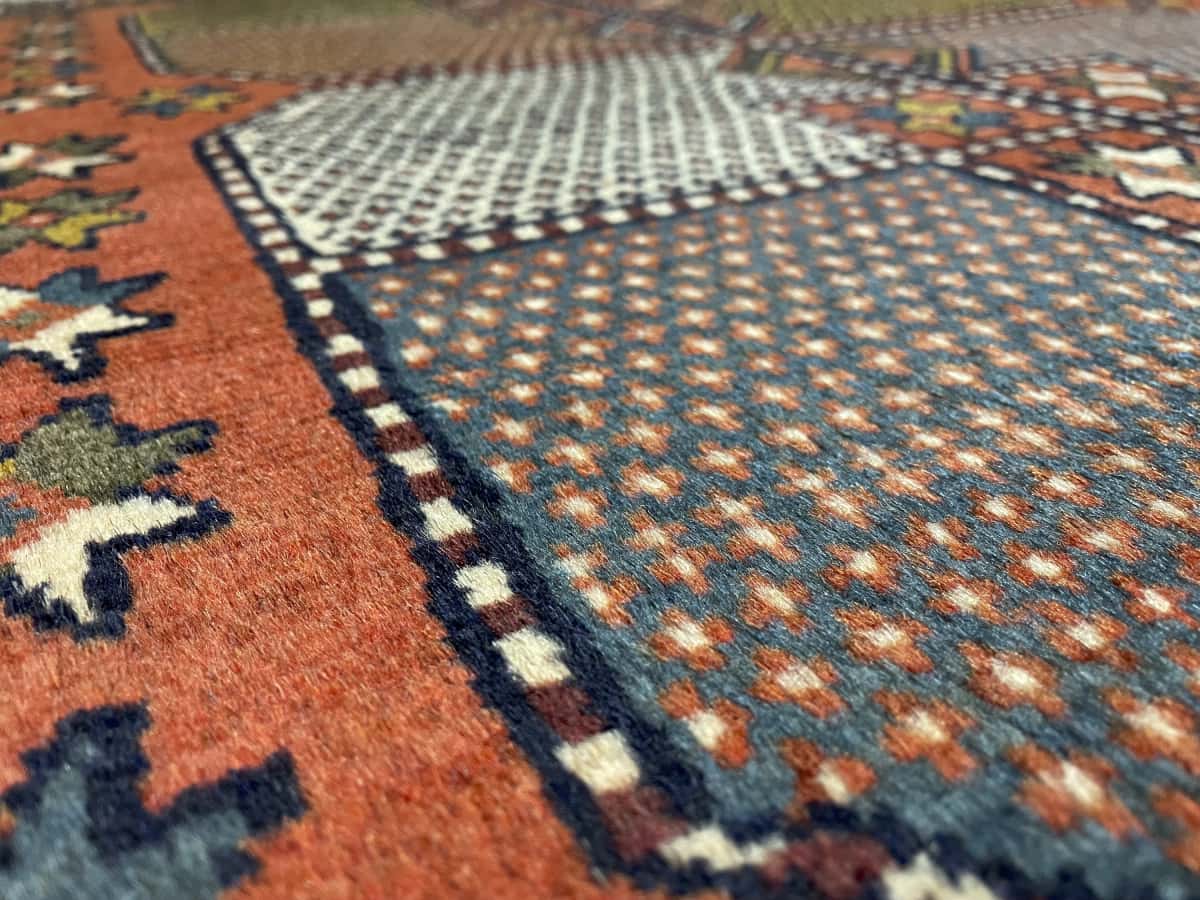 Persian rug of Quchan style in dimensions 185 centimeters length by 115 centimeters width with mainly orange colors — Texture close-up