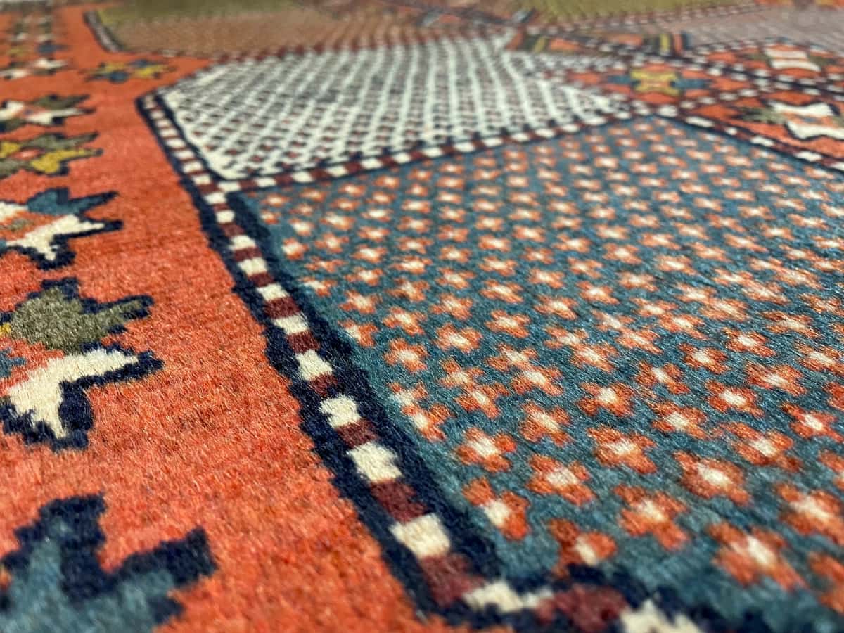 persischer Teppich im Quchan Stil in den Maßen 185 Zentimeter Länge mal 115 Zentimeter Breite mit überwiegend orange Farben — Nahaufnahme der Textur