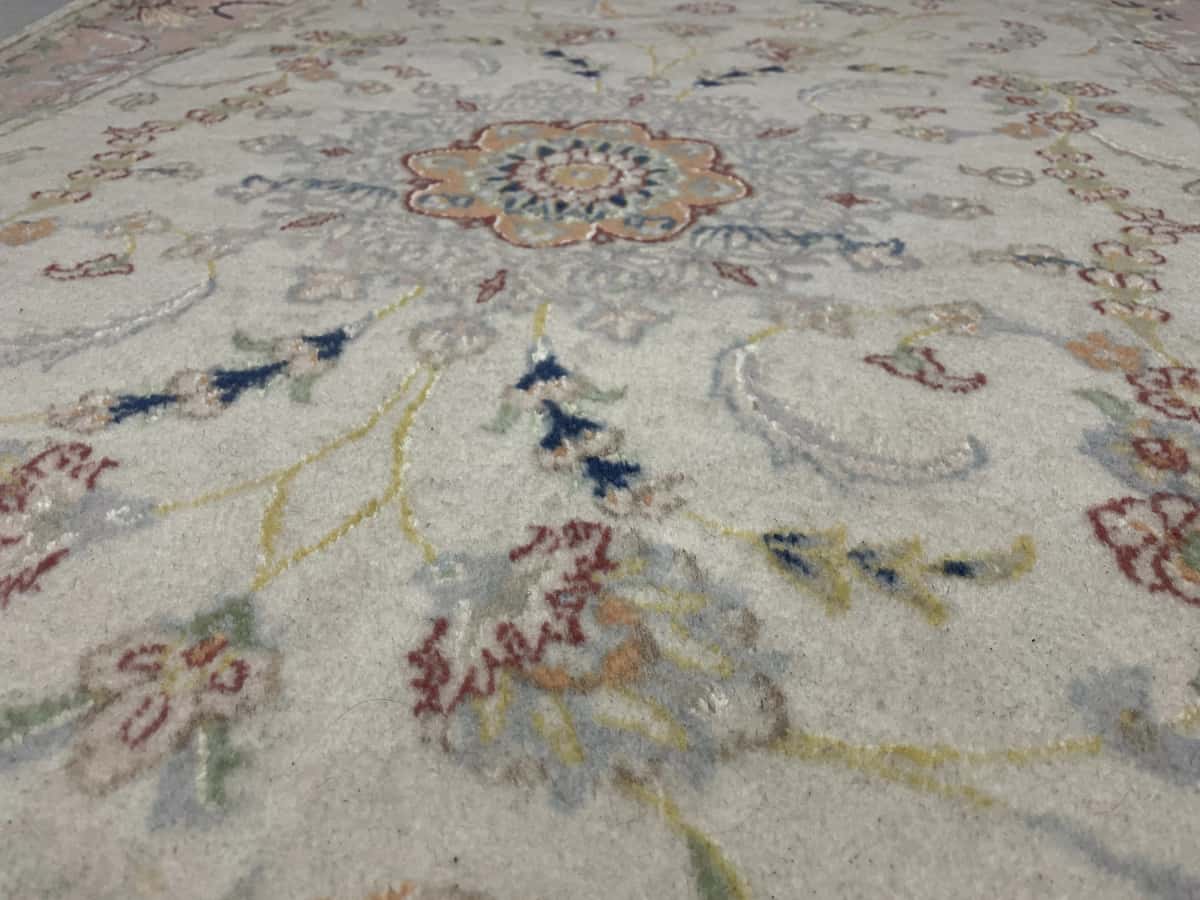 alfombra persa de estilo Tabriz en dimensiones 190 centímetros de largo por 124 centímetros de ancho con colores principalmente beige y rosa — Primer plano de la textura