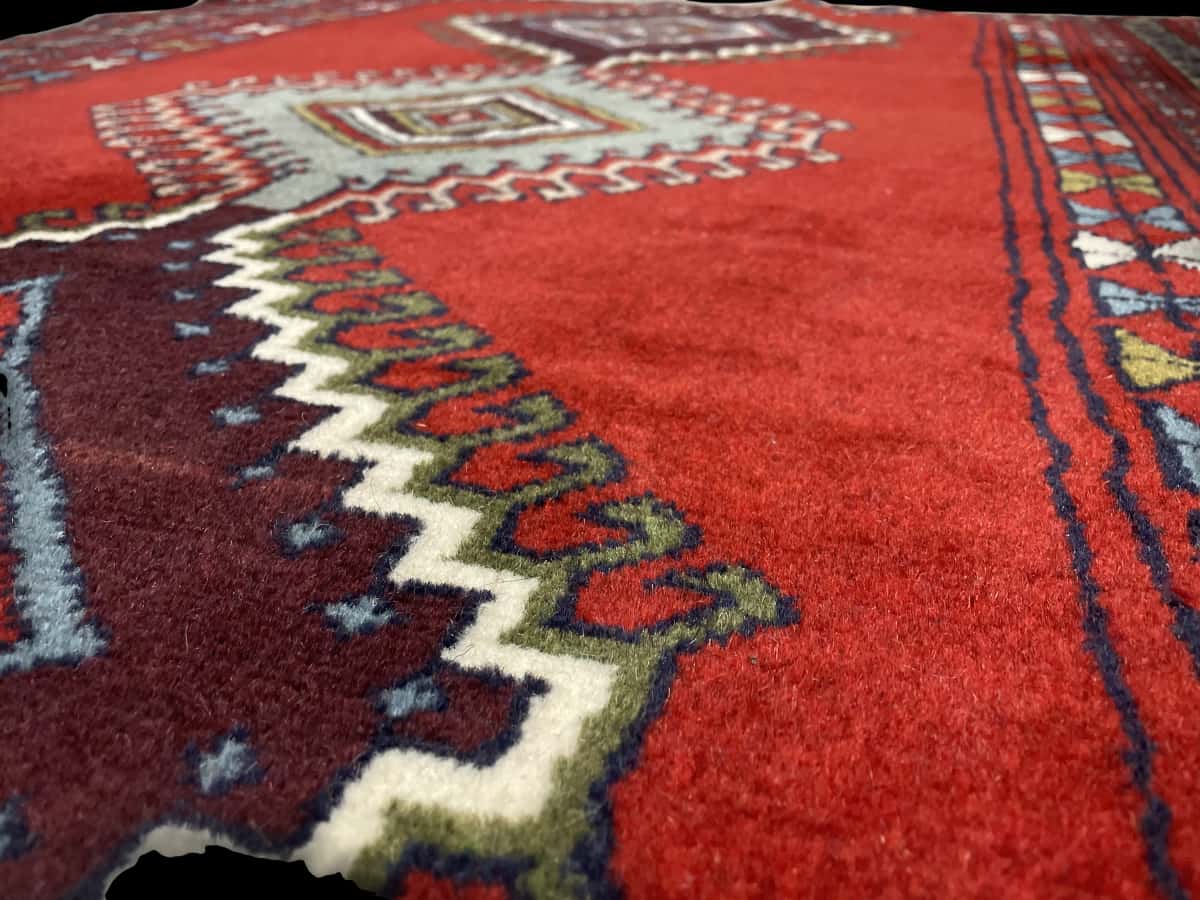 Persian rug of Quchan style in dimensions 162 centimeters length by 122 centimeters width with mainly red colors — Texture close-up