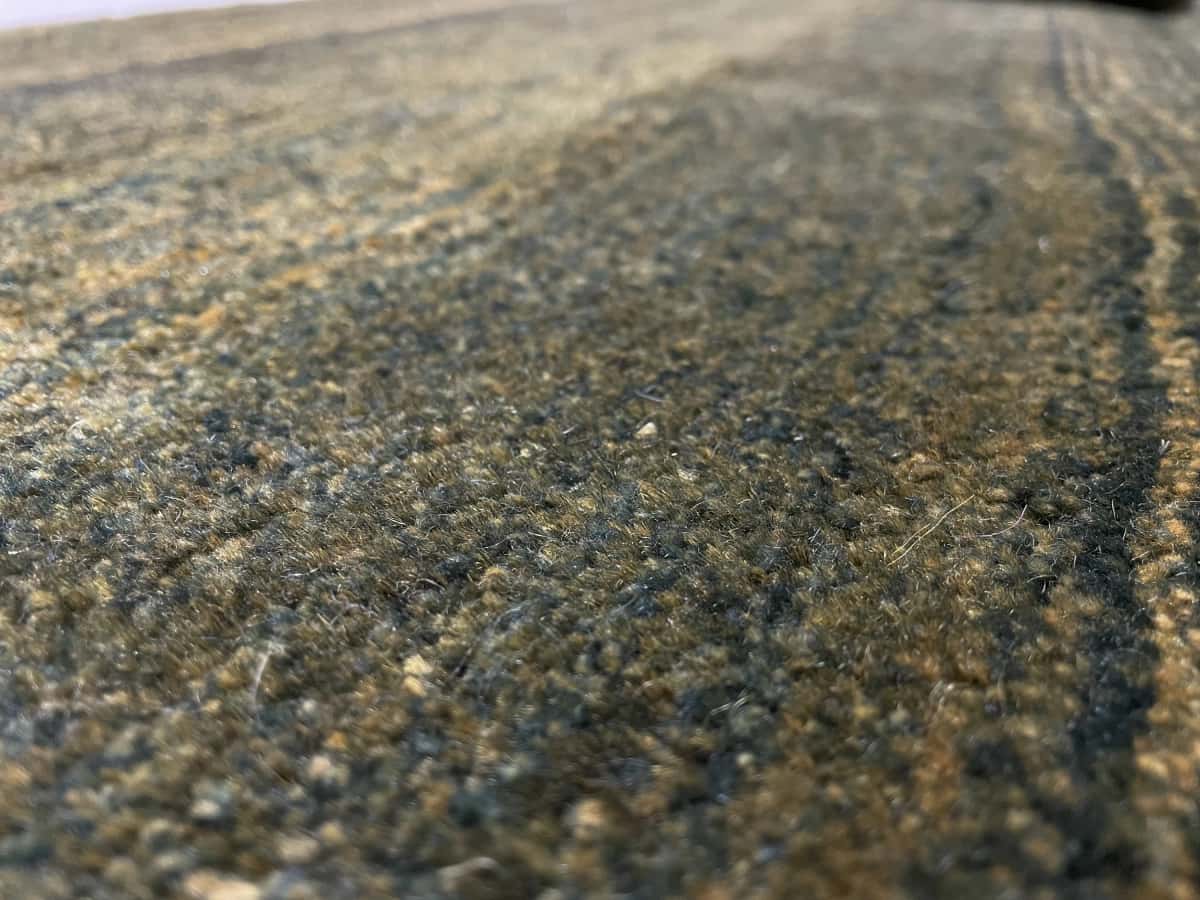 alfombra persa de estilo gabbeh en dimensiones 165 centímetros de largo por 75 centímetros de ancho con colores principalmente verde — Primer plano de la textura