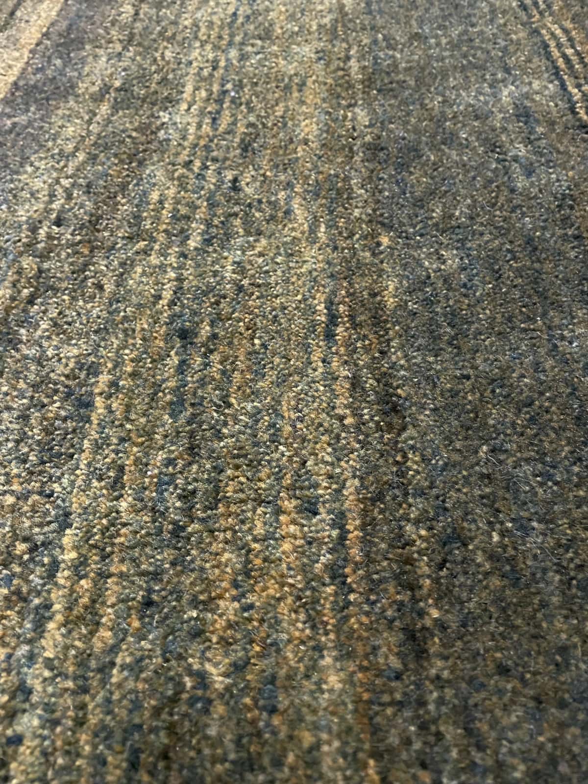 alfombra persa de estilo gabbeh en dimensiones 165 centímetros de largo por 75 centímetros de ancho con colores principalmente verde — Primer plano de la textura