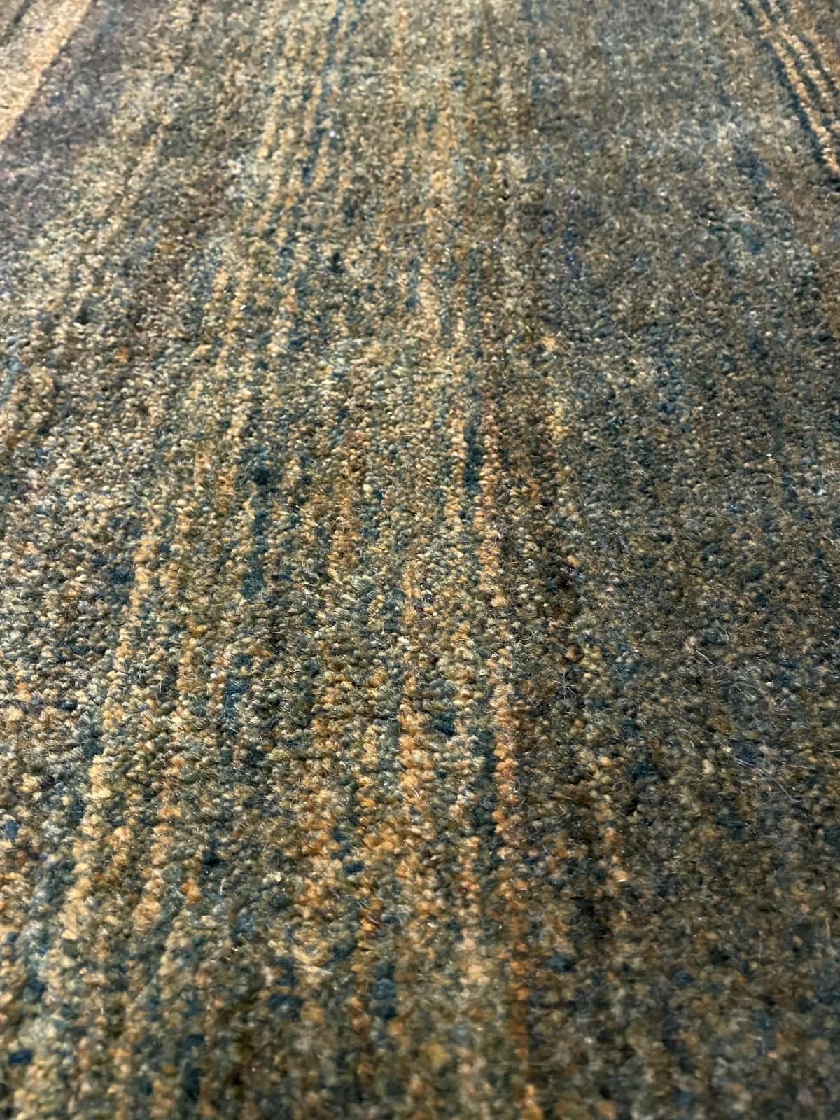 Persian rug of Gabbeh style in dimensions 165 centimeters length by 75 centimeters width with mainly green colors — Texture close-up
