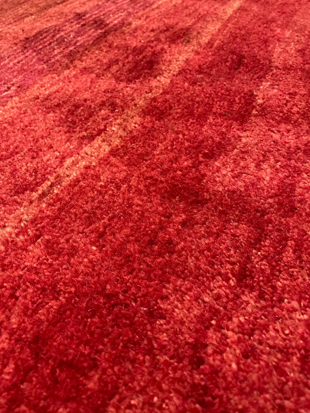 Persian rug of Gabbeh style in dimensions 156 centimeters length by 85 centimeters width with mainly red colors — Texture close-up