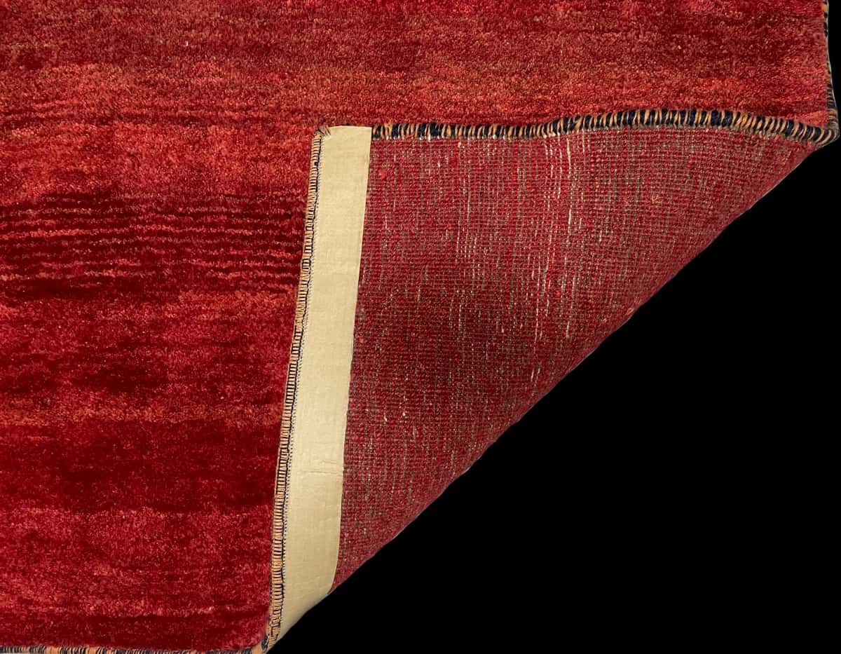 Persian rug of Gabbeh style in dimensions 156 centimeters length by 85 centimeters width with mainly red colors — Folded