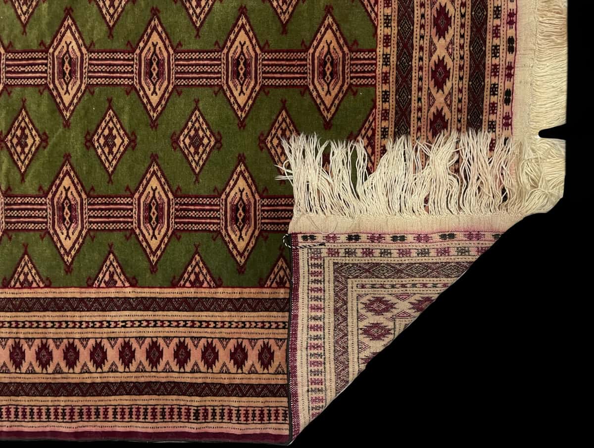 Persian rug of Turkoman style in dimensions 135 centimeters length by 97 centimeters width with mainly green and yellow colors — Folded