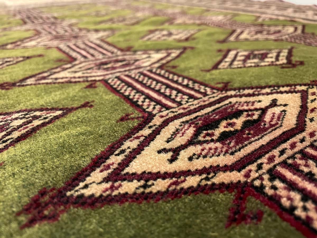 Persian rug of Turkoman style in dimensions 135 centimeters length by 97 centimeters width with mainly green and yellow colors — Texture close-up