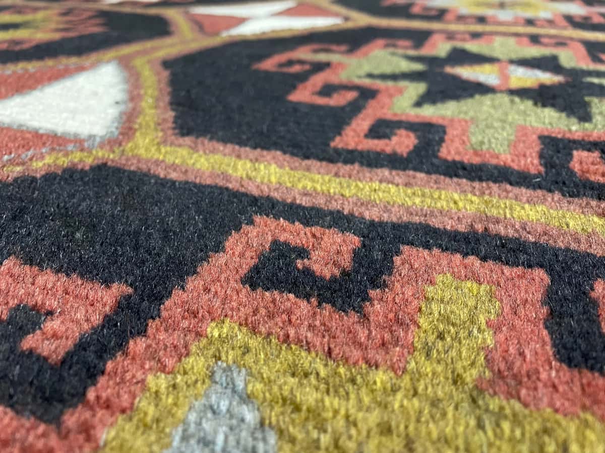 Persian rug of Quchan style in dimensions 164 centimeters length by 107 centimeters width with mainly black and brown colors — Texture close-up