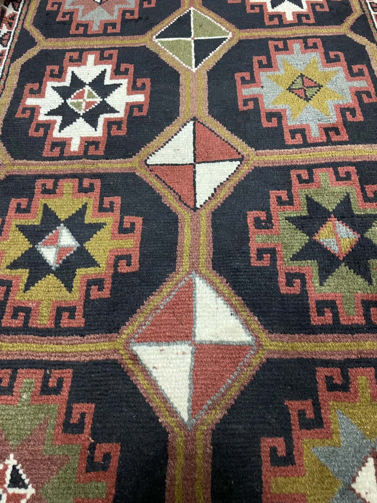 Persian rug of Quchan style in dimensions 164 centimeters length by 107 centimeters width with mainly black and brown colors — Texture close-up