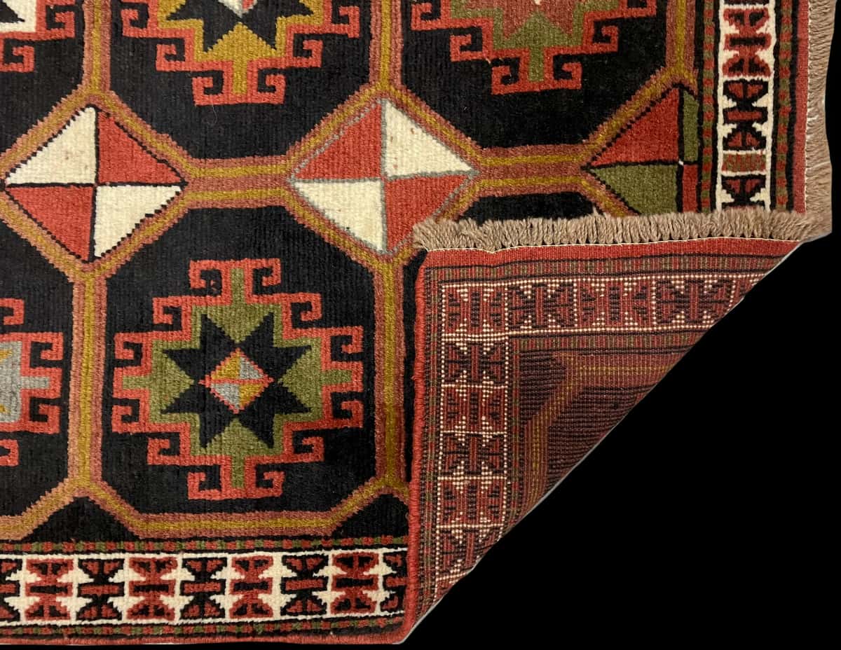 persischer Teppich im Quchan Stil in den Maßen 164 Zentimeter Länge mal 107 Zentimeter Breite mit überwiegend schwarz und braun Farben — Gefaltet