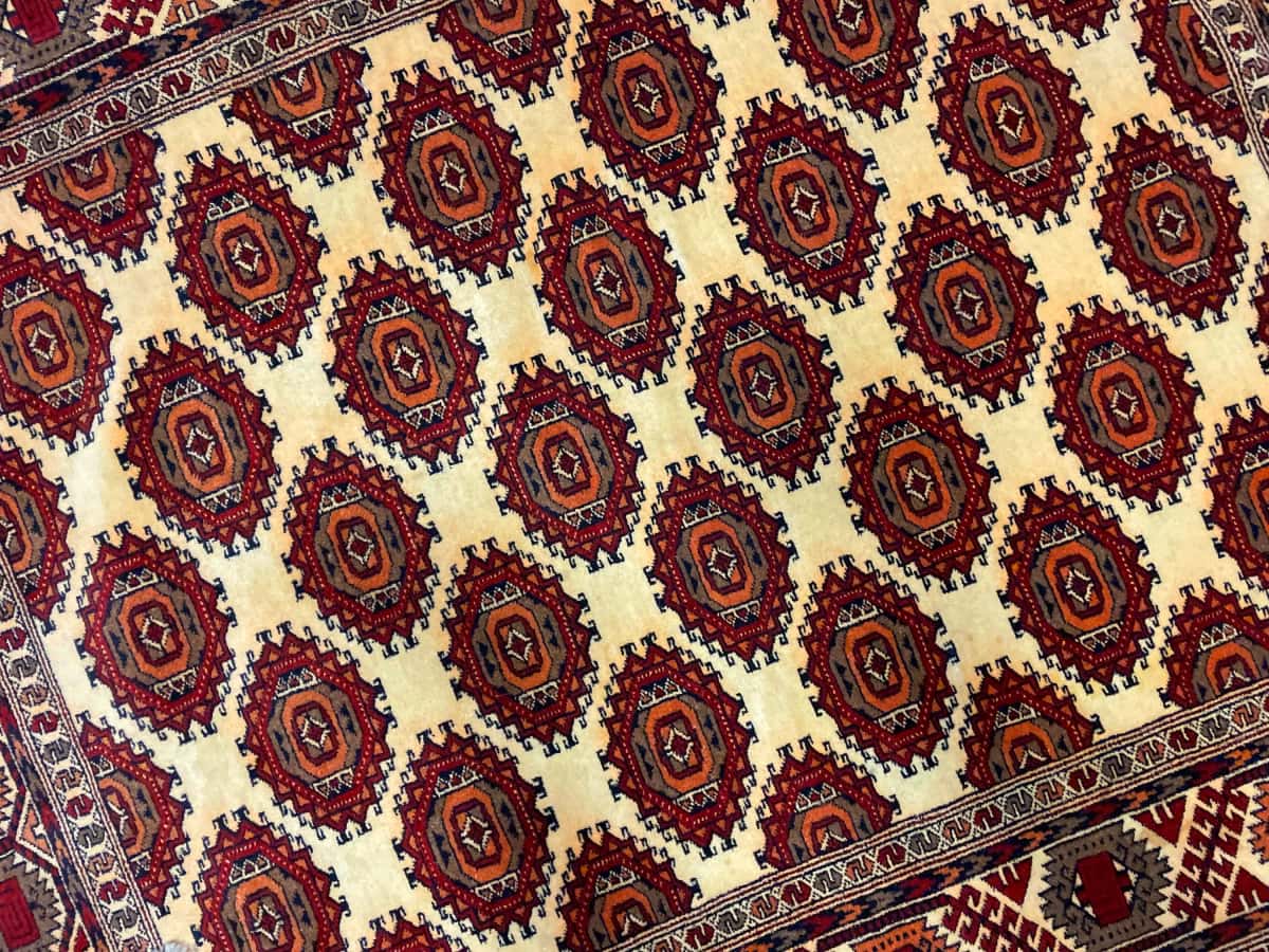persischer Teppich im turkmenischer Stil in den Maßen 196 Zentimeter Länge mal 140 Zentimeter Breite mit überwiegend gelb Farben — Nahaufnahme der Textur
