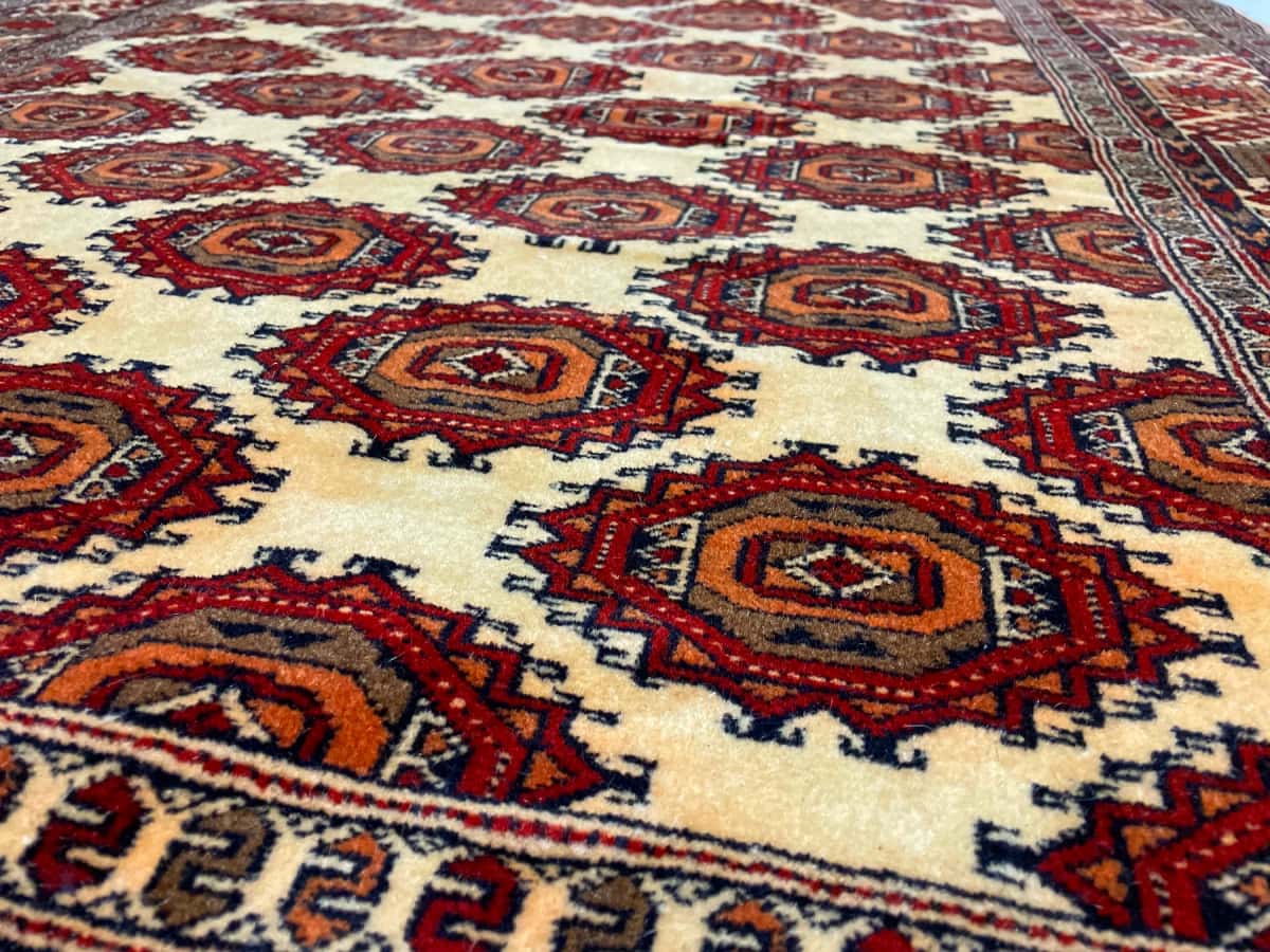 persischer Teppich im turkmenischer Stil in den Maßen 196 Zentimeter Länge mal 140 Zentimeter Breite mit überwiegend gelb Farben — Nahaufnahme der Textur