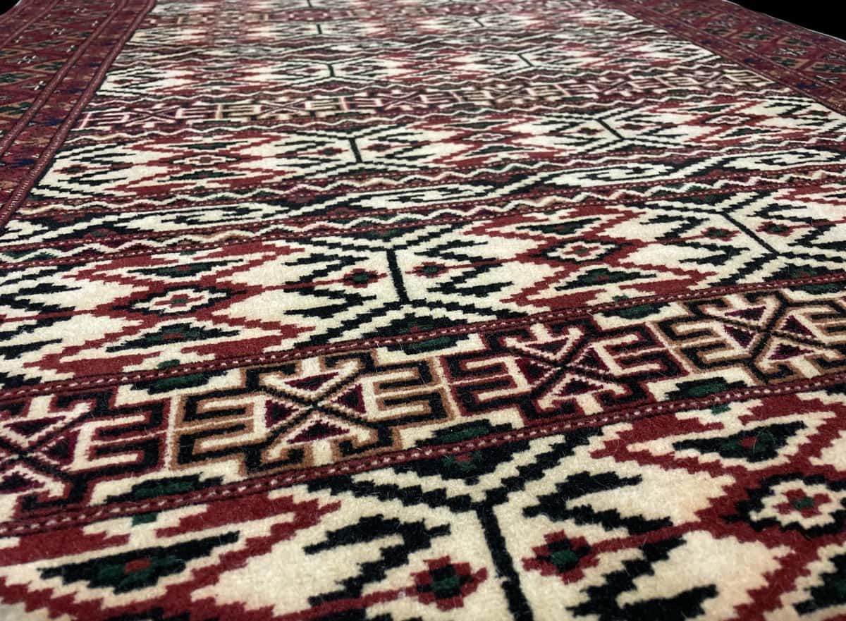 Persian rug of Turkoman style in dimensions 172 centimeters length by 114 centimeters width with mainly beige colors — Texture close-up