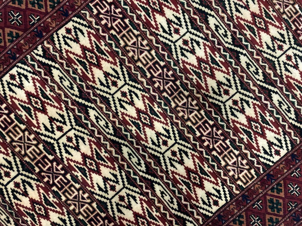 Persian rug of Turkoman style in dimensions 172 centimeters length by 114 centimeters width with mainly beige colors — Texture close-up