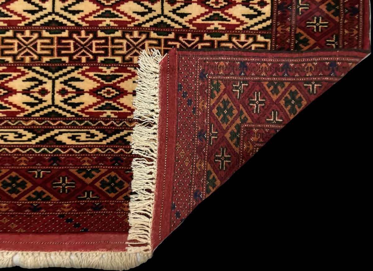 persischer Teppich im turkmenischer Stil in den Maßen 172 Zentimeter Länge mal 114 Zentimeter Breite mit überwiegend beige und rot Farben — Gefaltet