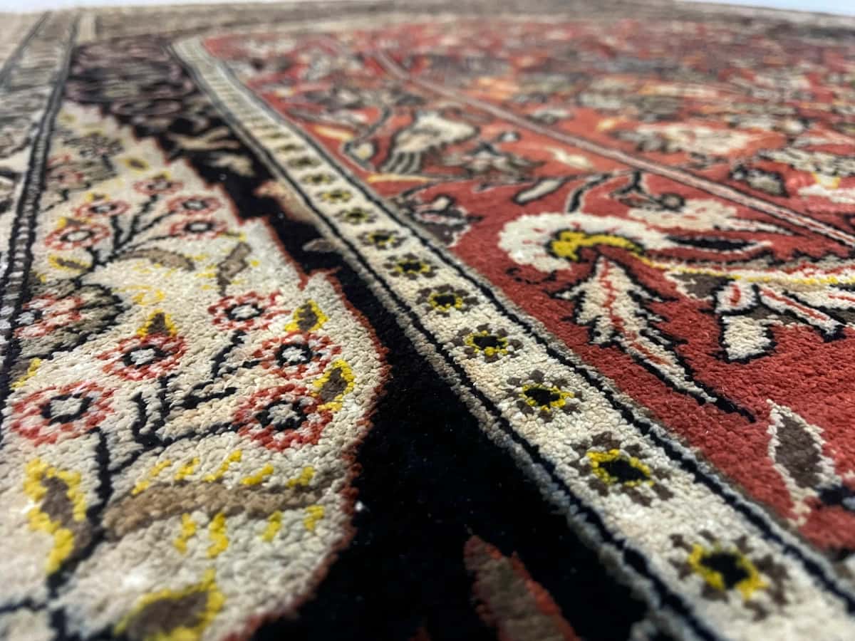 Persian rug of Arak style in dimensions 155 centimeters length by 108 centimeters width with mainly black and orange colors — Texture close-up