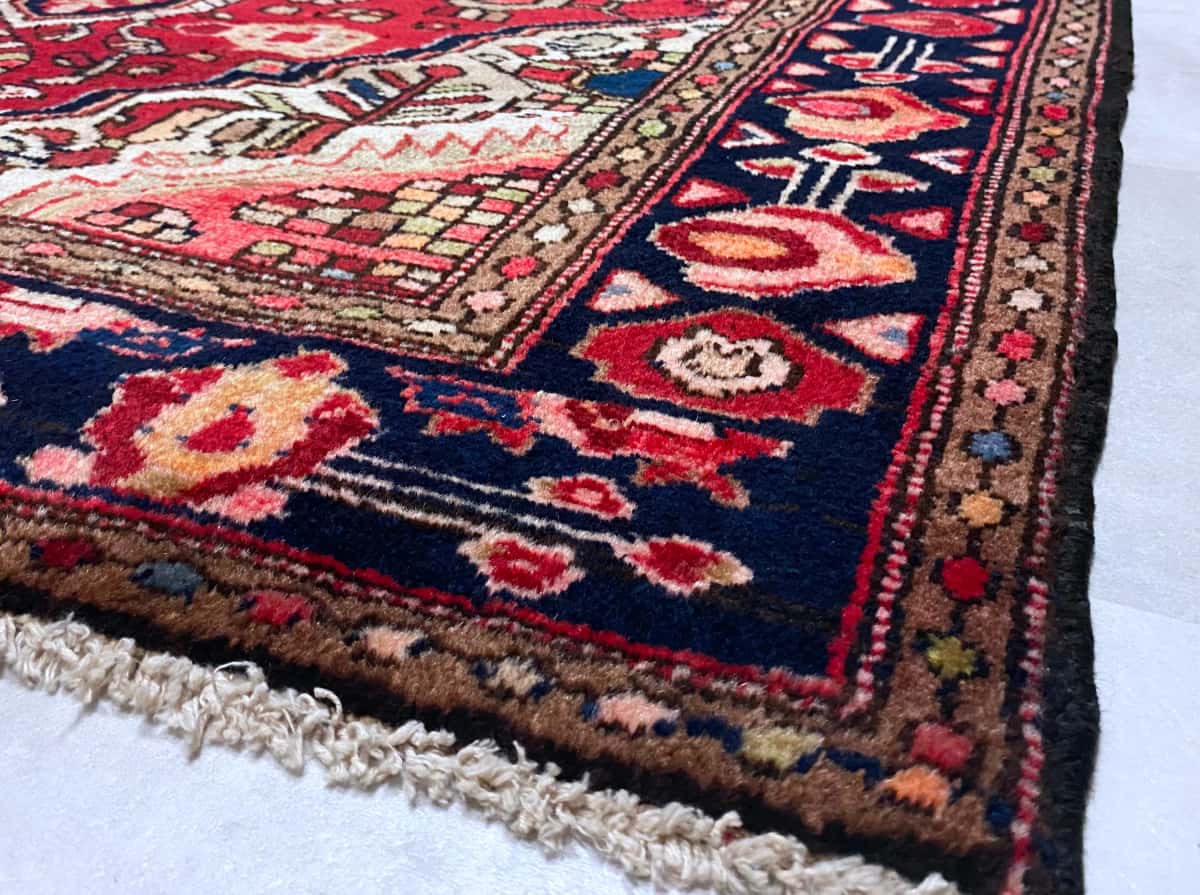 persischer Teppich in den Maßen 193 Zentimeter Länge mal 126 Zentimeter Breite mit überwiegend rot Farben — Ecke & Kante