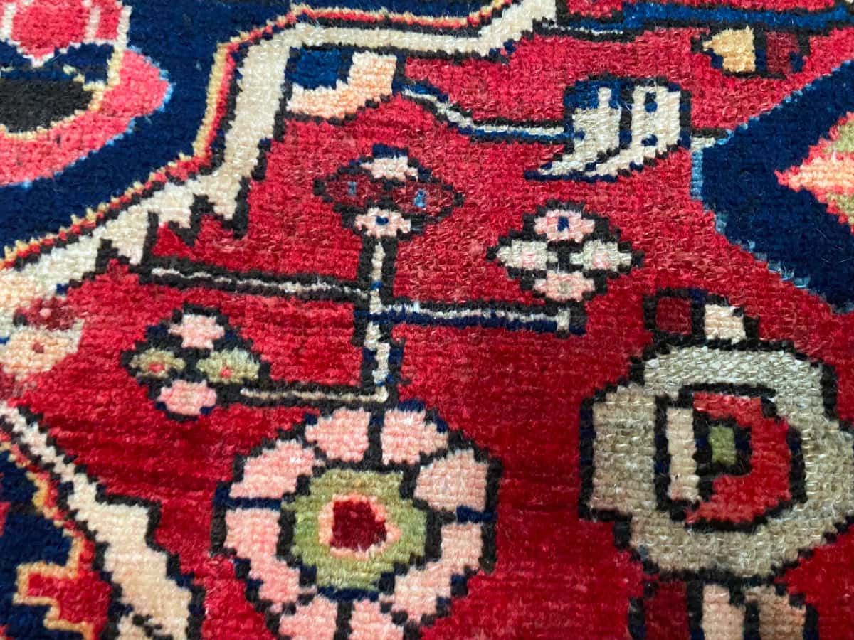 persischer Teppich in den Maßen 193 Zentimeter Länge mal 126 Zentimeter Breite mit überwiegend rot Farben — Nahaufnahme der Textur