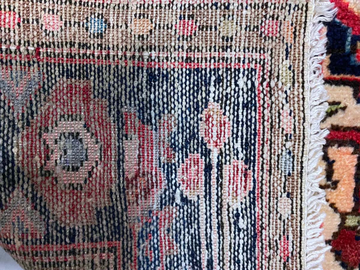 persischer Teppich in den Maßen 193 Zentimeter Länge mal 126 Zentimeter Breite mit überwiegend rot Farben — Knotendetail
