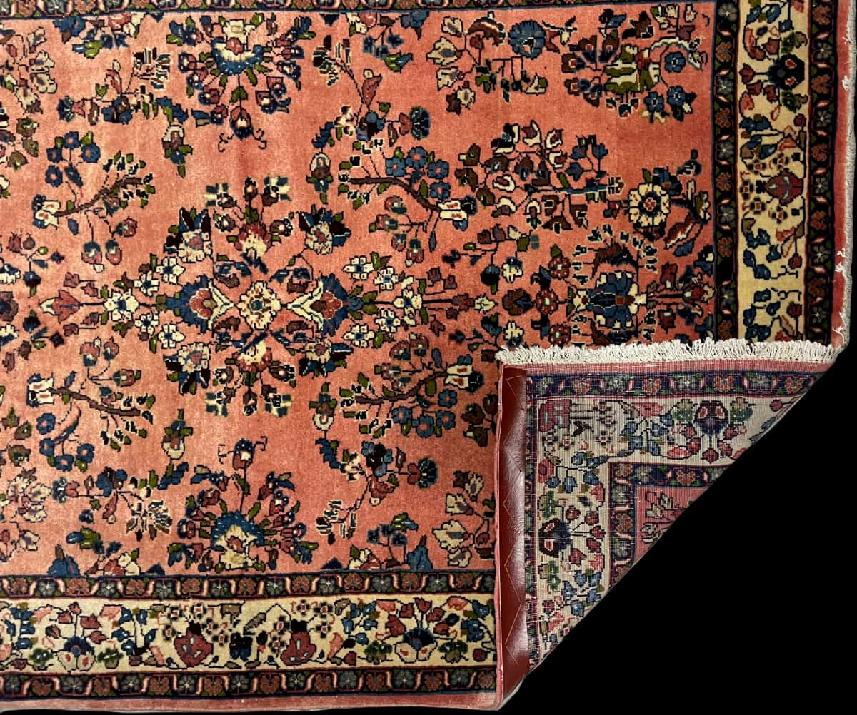 persischer Teppich im Saruq Stil in den Maßen 158 Zentimeter Länge mal 108 Zentimeter Breite mit überwiegend rosa Farben — Gefaltet