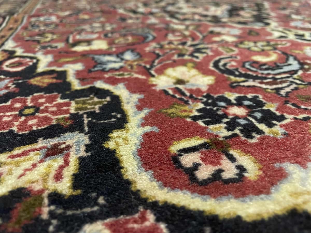 Persian rug of Ardakan style in dimensions 146 centimeters length by 105 centimeters width with mainly red colors — Texture close-up