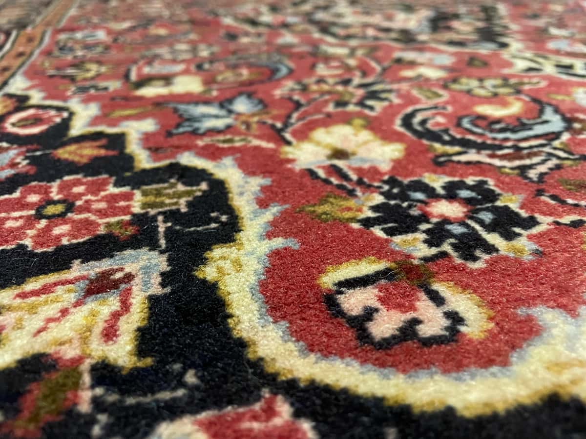 persischer Teppich im Ardakan Stil in den Maßen 146 Zentimeter Länge mal 105 Zentimeter Breite mit überwiegend rot Farben — Nahaufnahme der Textur