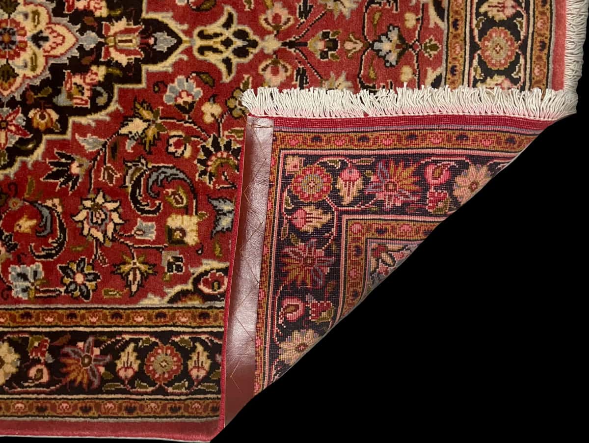 persischer Teppich im Ardakan Stil in den Maßen 146 Zentimeter Länge mal 105 Zentimeter Breite mit überwiegend rot Farben — Gefaltet