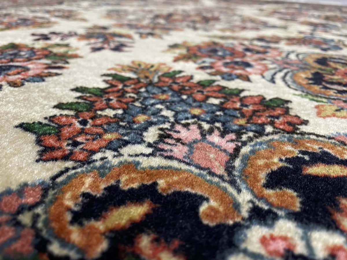 Persian rug in dimensions 145 centimeters length by 112 centimeters width with mainly beige colors — Texture close-up