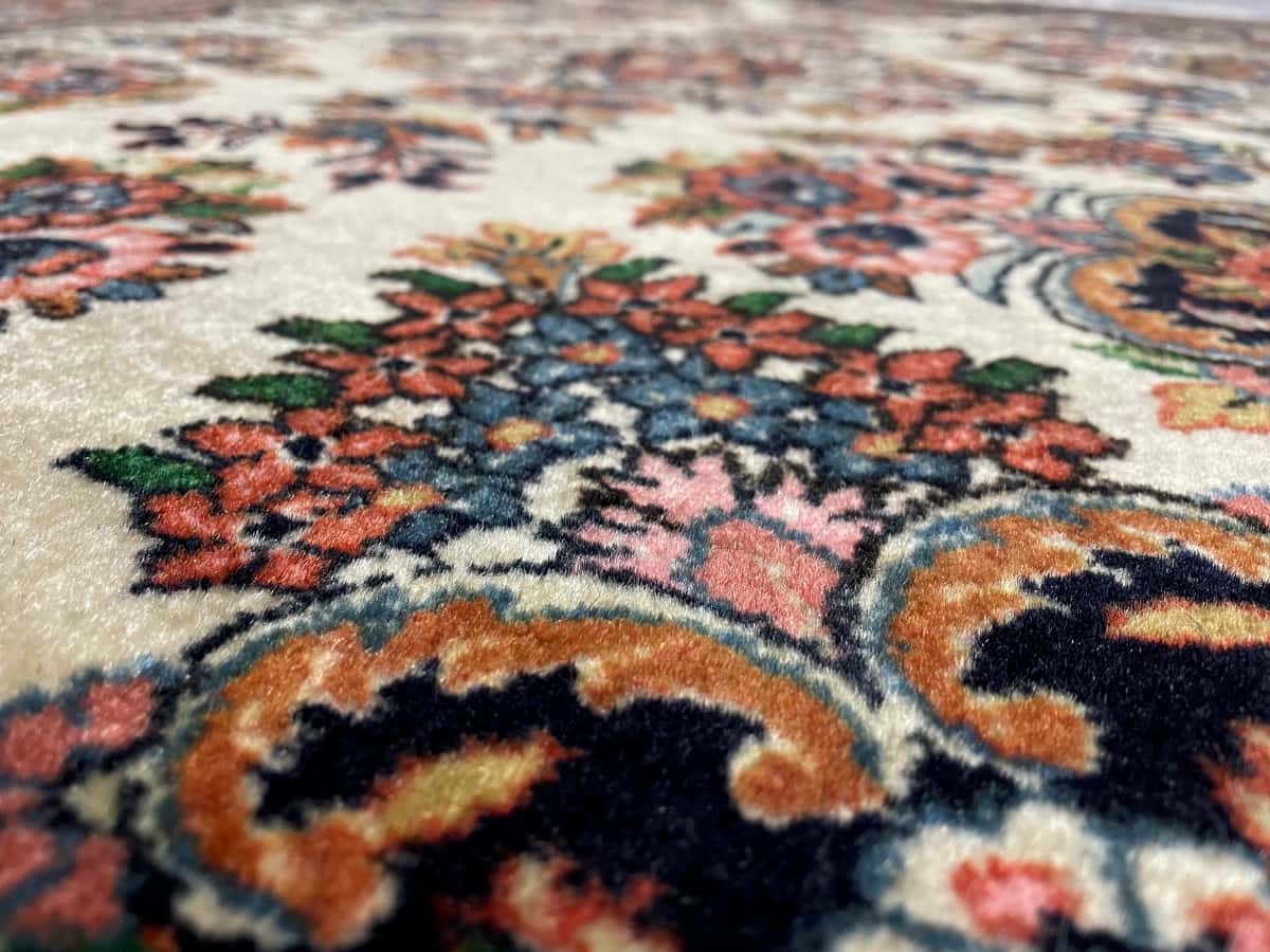 persischer Teppich in den Maßen 145 Zentimeter Länge mal 112 Zentimeter Breite mit überwiegend beige und braun Farben — Nahaufnahme der Textur