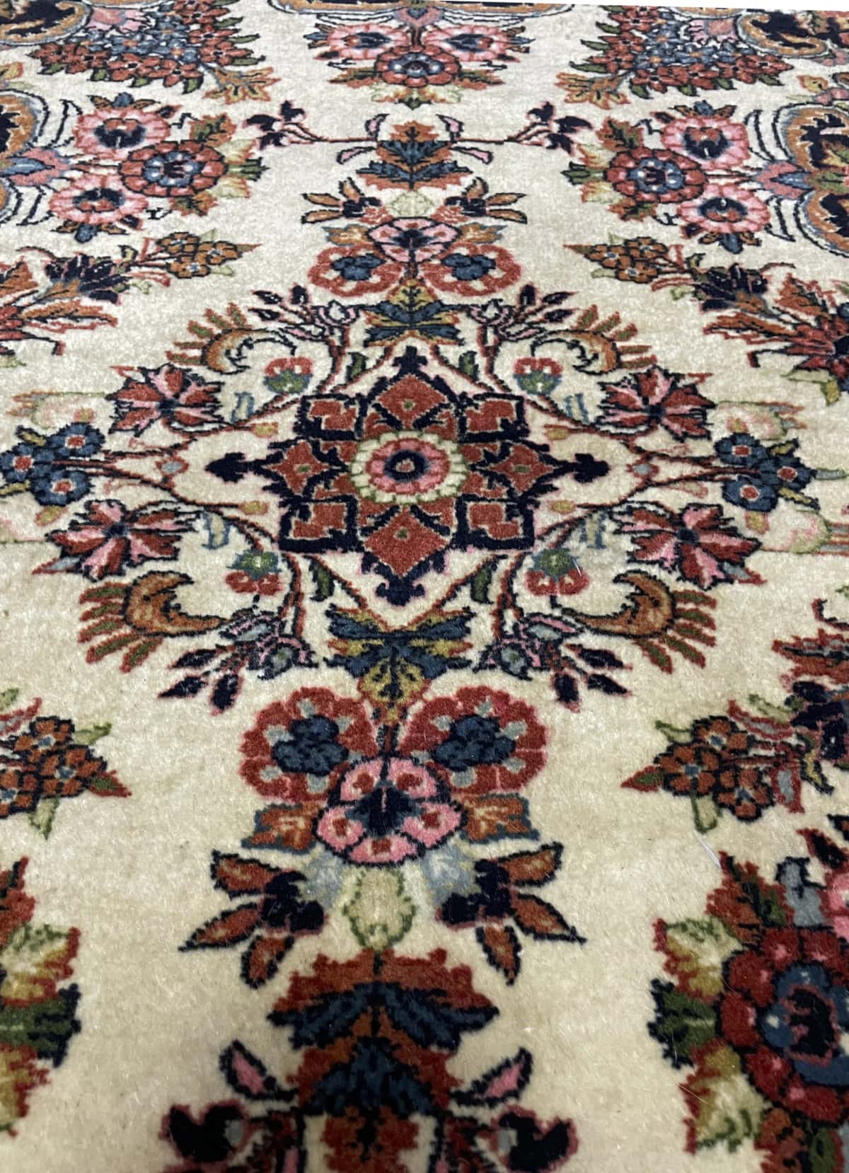Persian rug in dimensions 145 centimeters length by 112 centimeters width with mainly beige colors — Texture close-up