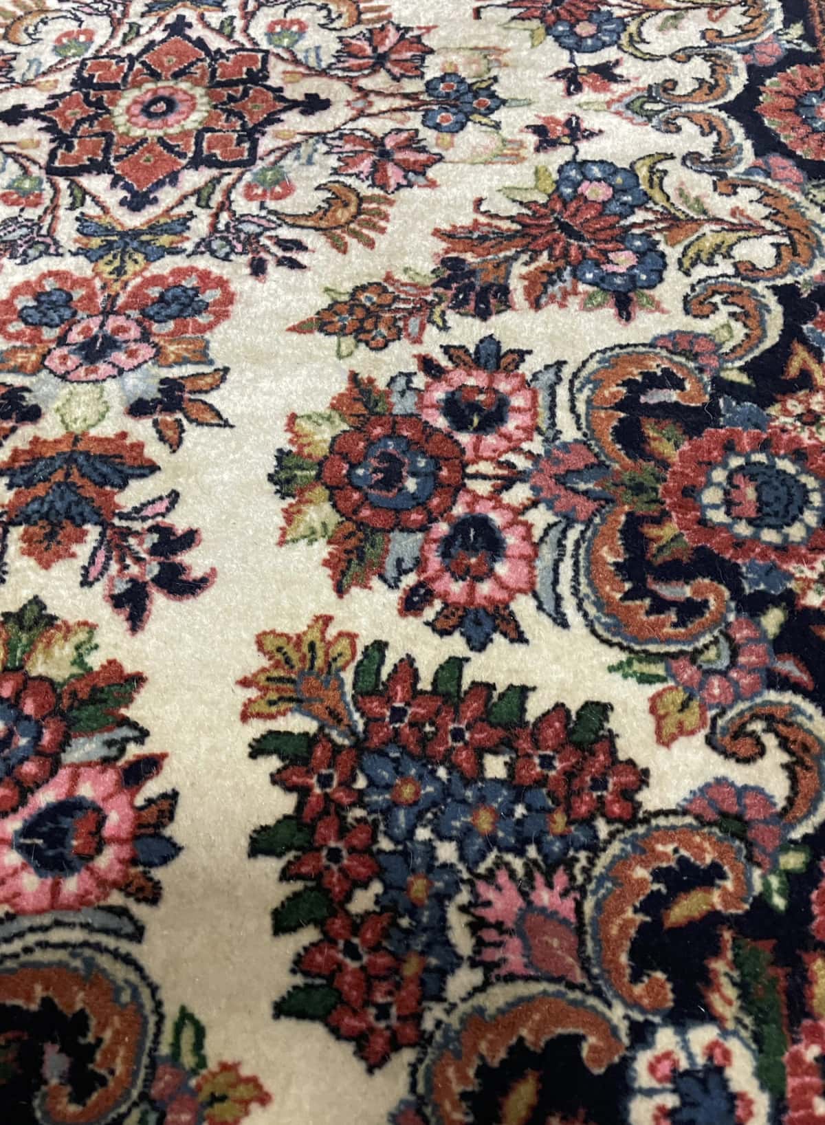 Persian rug in dimensions 145 centimeters length by 112 centimeters width with mainly beige colors — Texture close-up