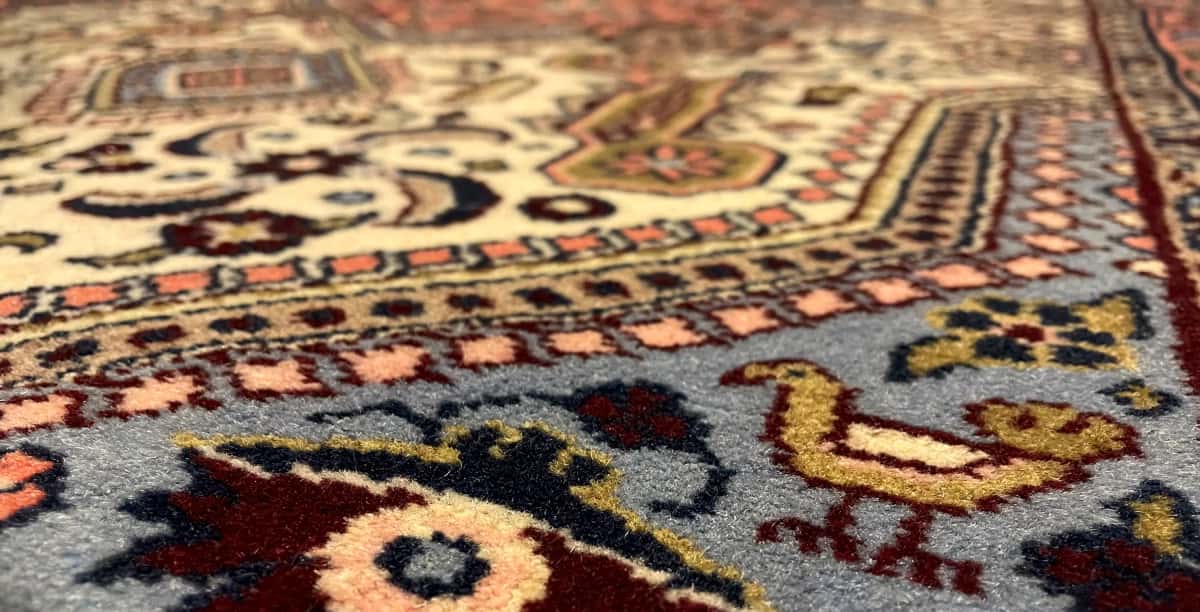 persischer Teppich im Hamadan Stil in den Maßen 148 Zentimeter Länge mal 98 Zentimeter Breite mit überwiegend beige und orange Farben — Nahaufnahme der Textur