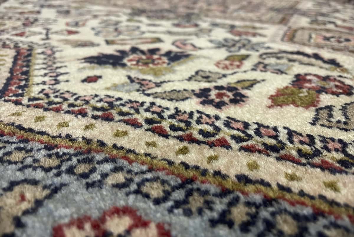 Persian rug in dimensions 153 centimeters length by 108 centimeters width with mainly beige colors — Texture close-up