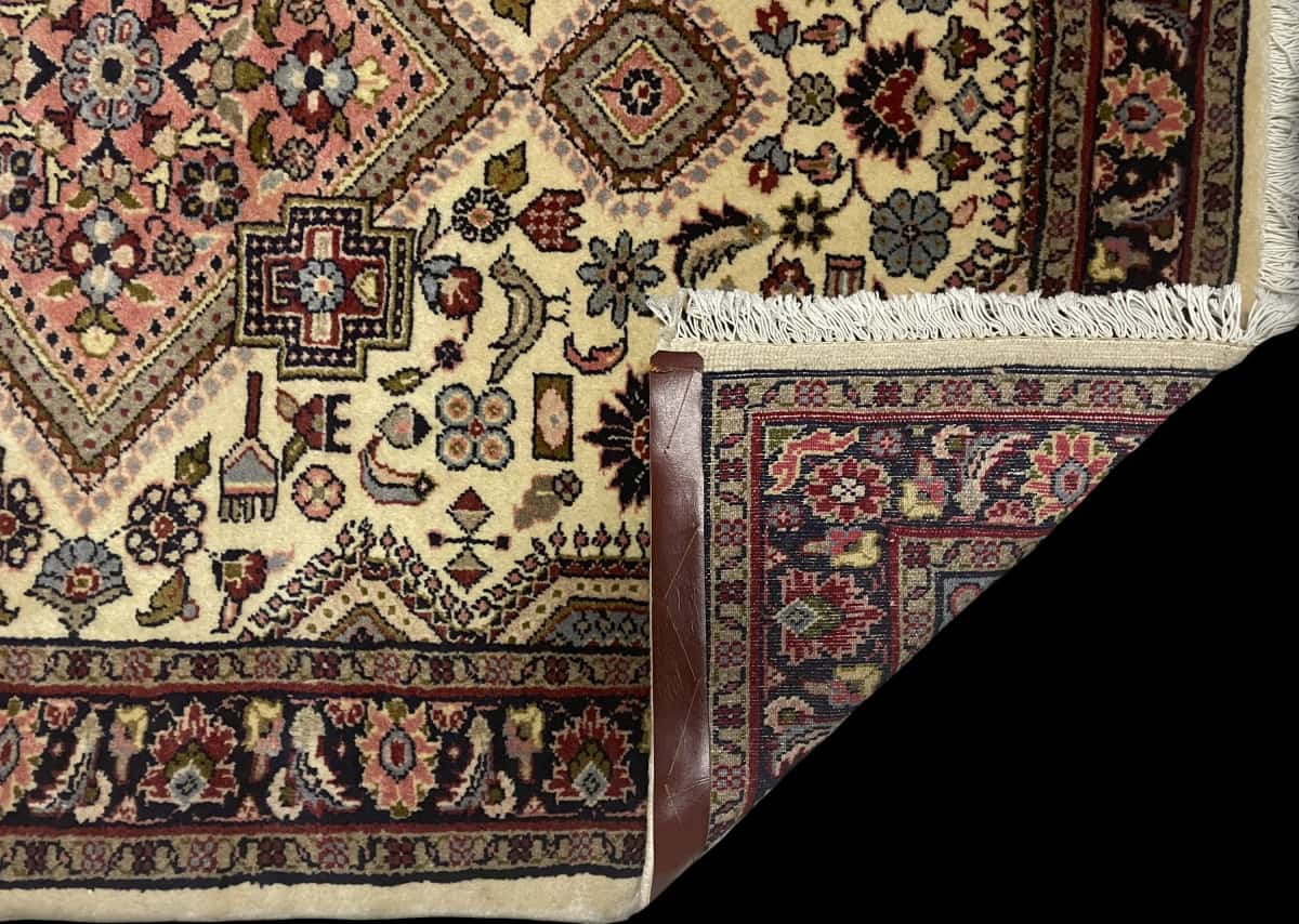 Persian rug in dimensions 153 centimeters length by 108 centimeters width with mainly beige colors — Folded