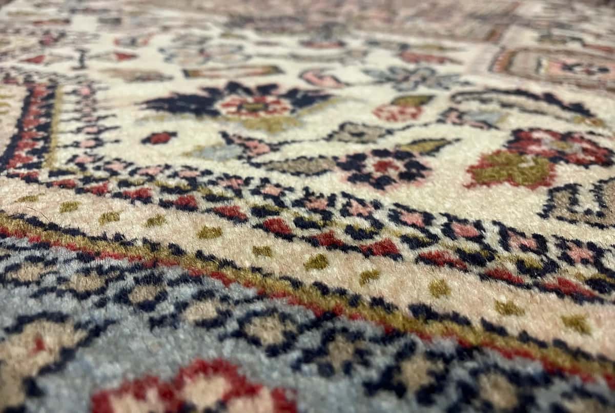 alfombra persa en dimensiones 153 centímetros de largo por 108 centímetros de ancho con colores principalmente beige — Primer plano de la textura