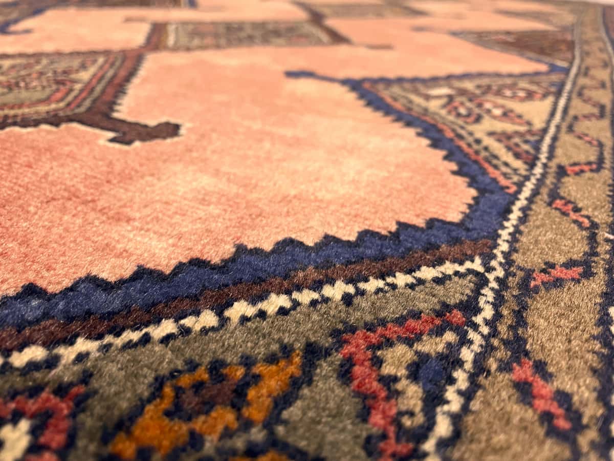 Persian rug of Hamadan style in dimensions 147 centimeters length by 95 centimeters width with mainly pink colors — Texture close-up