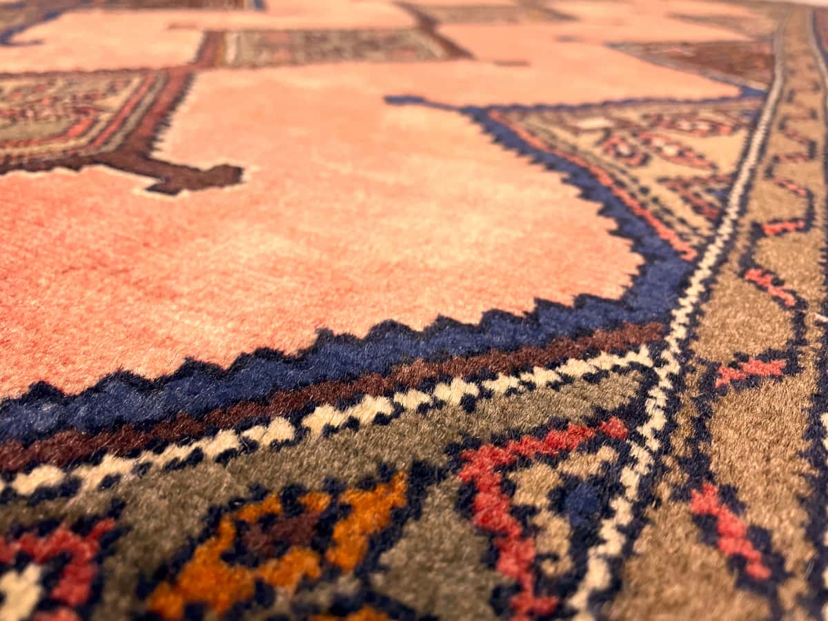 persischer Teppich im Hamadan Stil in den Maßen 147 Zentimeter Länge mal 95 Zentimeter Breite mit überwiegend rosa Farben — Nahaufnahme der Textur