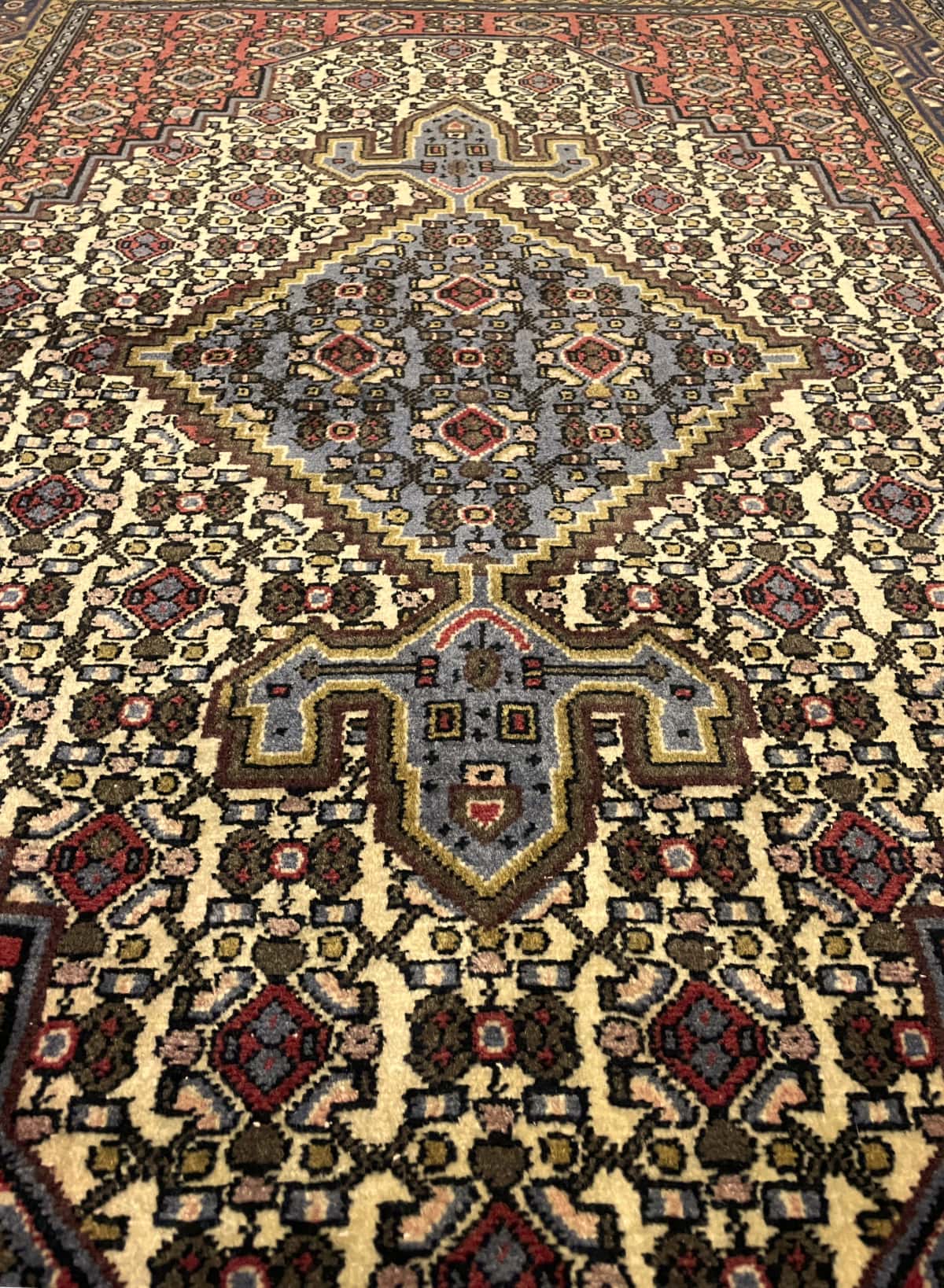 alfombra persa de estilo Hamadán en dimensiones 165 centímetros de largo por 112 centímetros de ancho con colores principalmente rojo y beige — Perspectiva