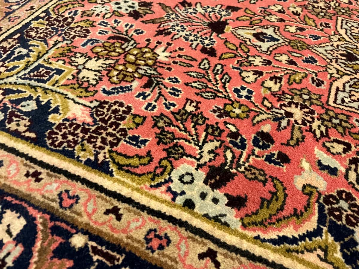 persischer Teppich im Hamadan Stil in den Maßen 150 Zentimeter Länge mal 100 Zentimeter Breite mit überwiegend rosa und rot Farben — Nahaufnahme der Textur