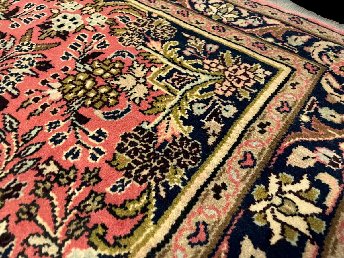persischer Teppich im Hamadan Stil in den Maßen 150 Zentimeter Länge mal 100 Zentimeter Breite mit überwiegend rosa und rot Farben — Nahaufnahme der Textur