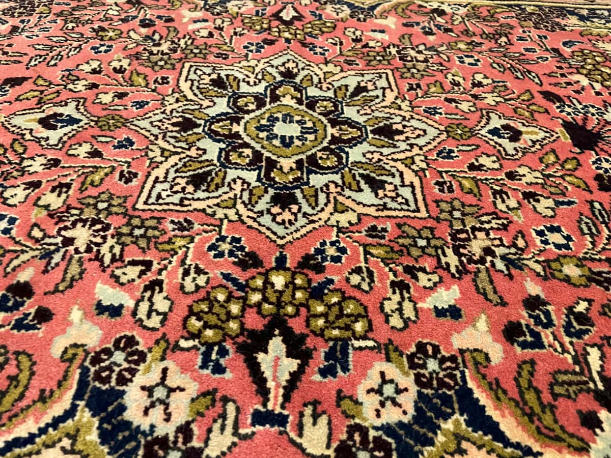 persischer Teppich im Hamadan Stil in den Maßen 150 Zentimeter Länge mal 100 Zentimeter Breite mit überwiegend rosa und rot Farben — Nahaufnahme der Textur