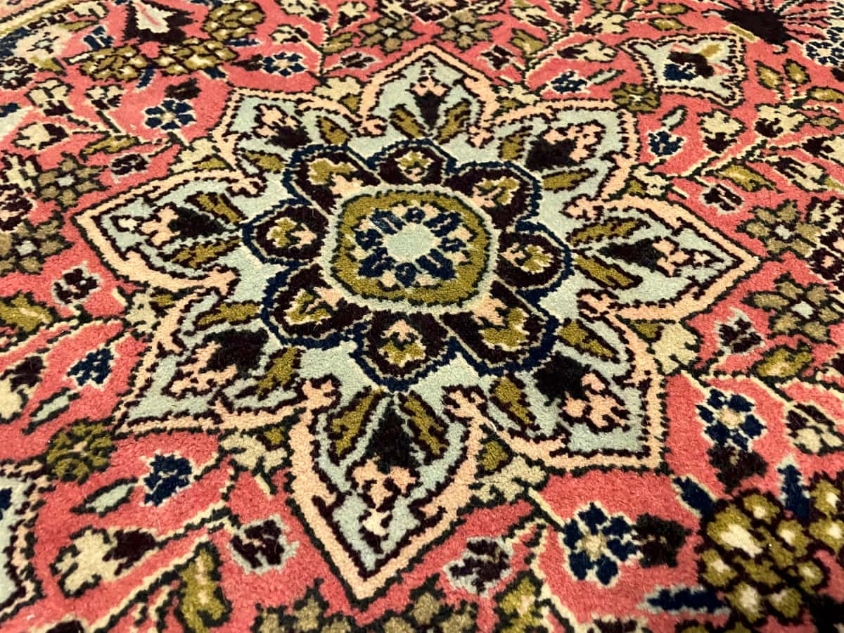 persischer Teppich im Hamadan Stil in den Maßen 150 Zentimeter Länge mal 100 Zentimeter Breite mit überwiegend rosa und rot Farben — Nahaufnahme der Textur