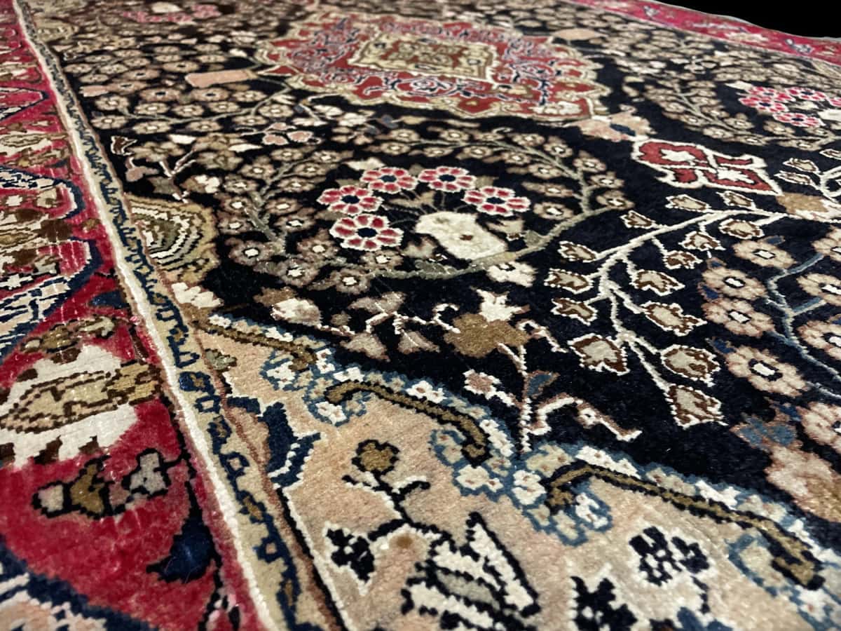 Persian rug of Sanandaj style in dimensions 183 centimeters length by 112 centimeters width with mainly black colors — Texture close-up