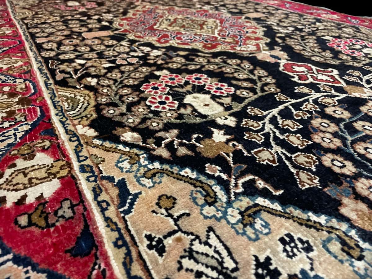 persischer Teppich im Sanandaj Stil in den Maßen 183 Zentimeter Länge mal 112 Zentimeter Breite mit überwiegend schwarz und rot Farben — Nahaufnahme der Textur