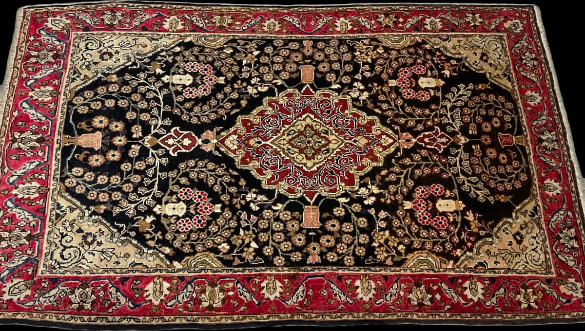 persischer Teppich im Sanandaj Stil in den Maßen 183 Zentimeter Länge mal 112 Zentimeter Breite mit überwiegend schwarz und rot Farben — Perspektive