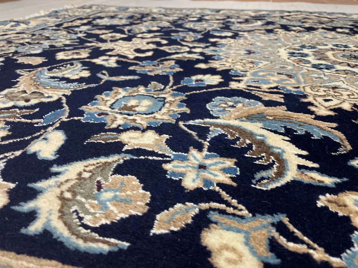 Persian rug of Nain style in dimensions 198 centimeters length by 142 centimeters width with mainly blue colors — Texture close-up