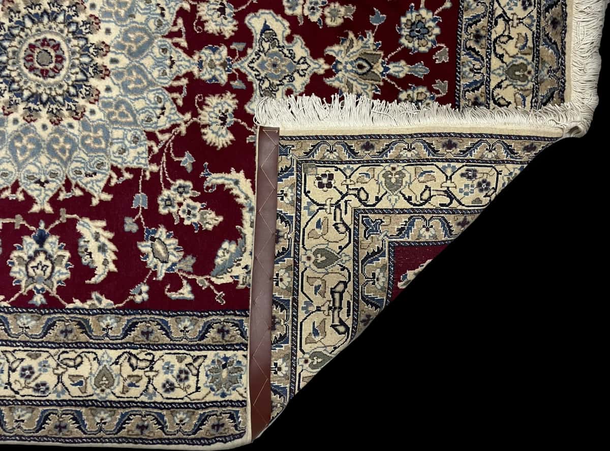 Persian rug of Nain style in dimensions 203 centimeters length by 145 centimeters width with mainly red colors — Folded