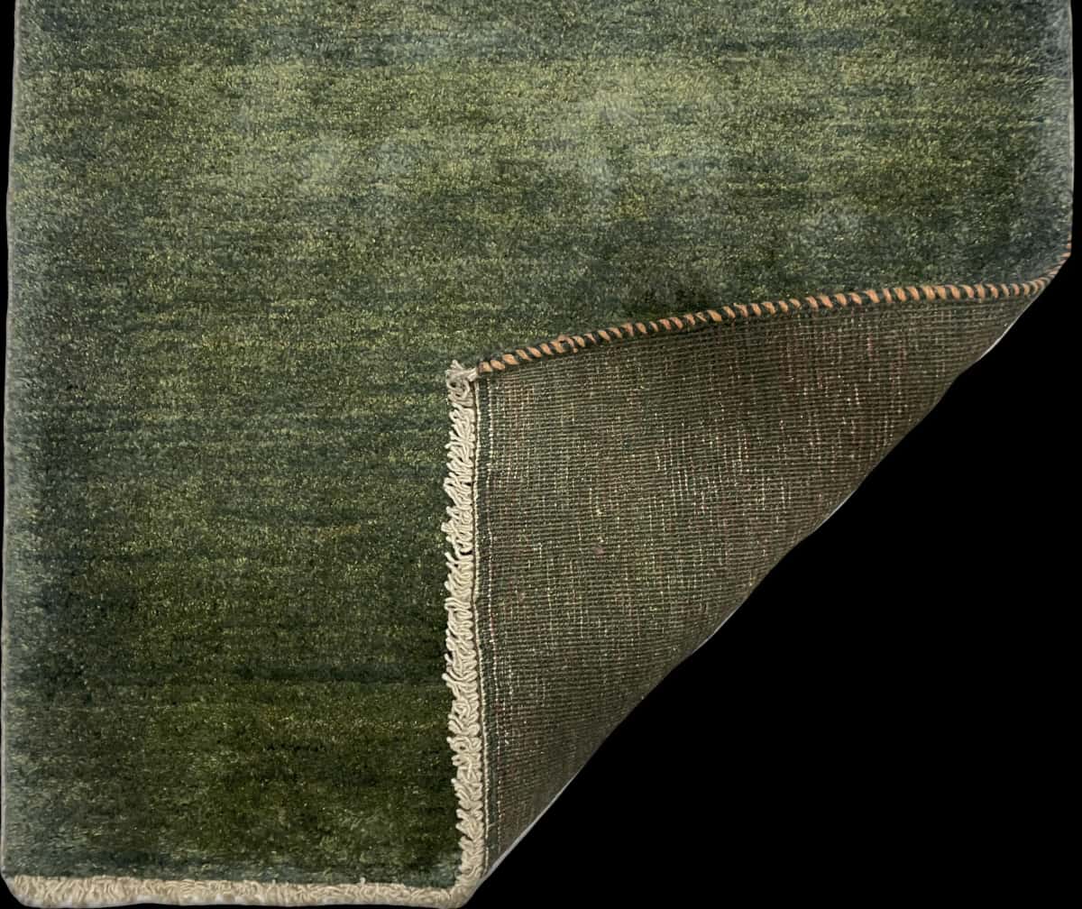 alfombra persa de estilo gabbeh en dimensiones 122 centímetros de largo por 90 centímetros de ancho con colores principalmente verde — Plegada