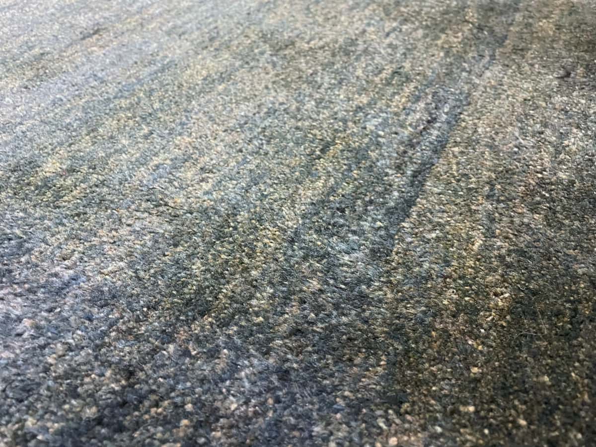 Persian rug of Gabbeh style in dimensions 122 centimeters length by 90 centimeters width with mainly green colors — Texture close-up